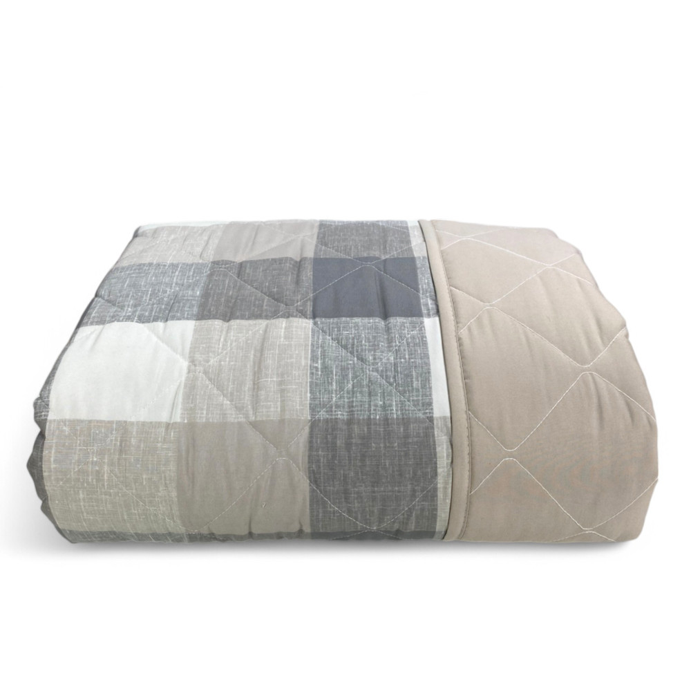 Quilted bedspread fabric detail – classic tartan pattern with diamond stitching