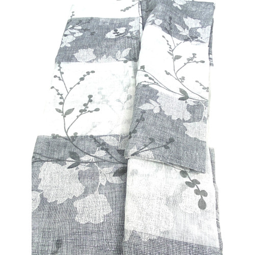 Tejido semitransparente de la cortina Olinka con textura floral y detalles visibles en la mano.