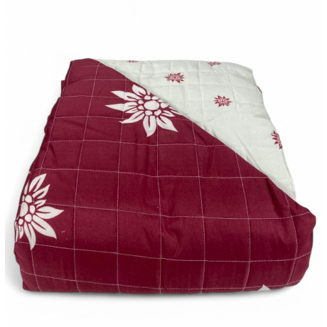 Copriletto trapuntato Edelweiss rosso con fiori bianchi su letto rustico 2