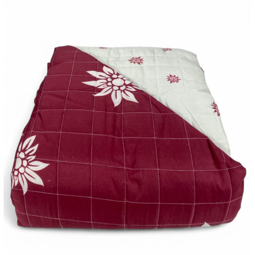 Folded view of red Edelweiss bedspread with ornate light interior